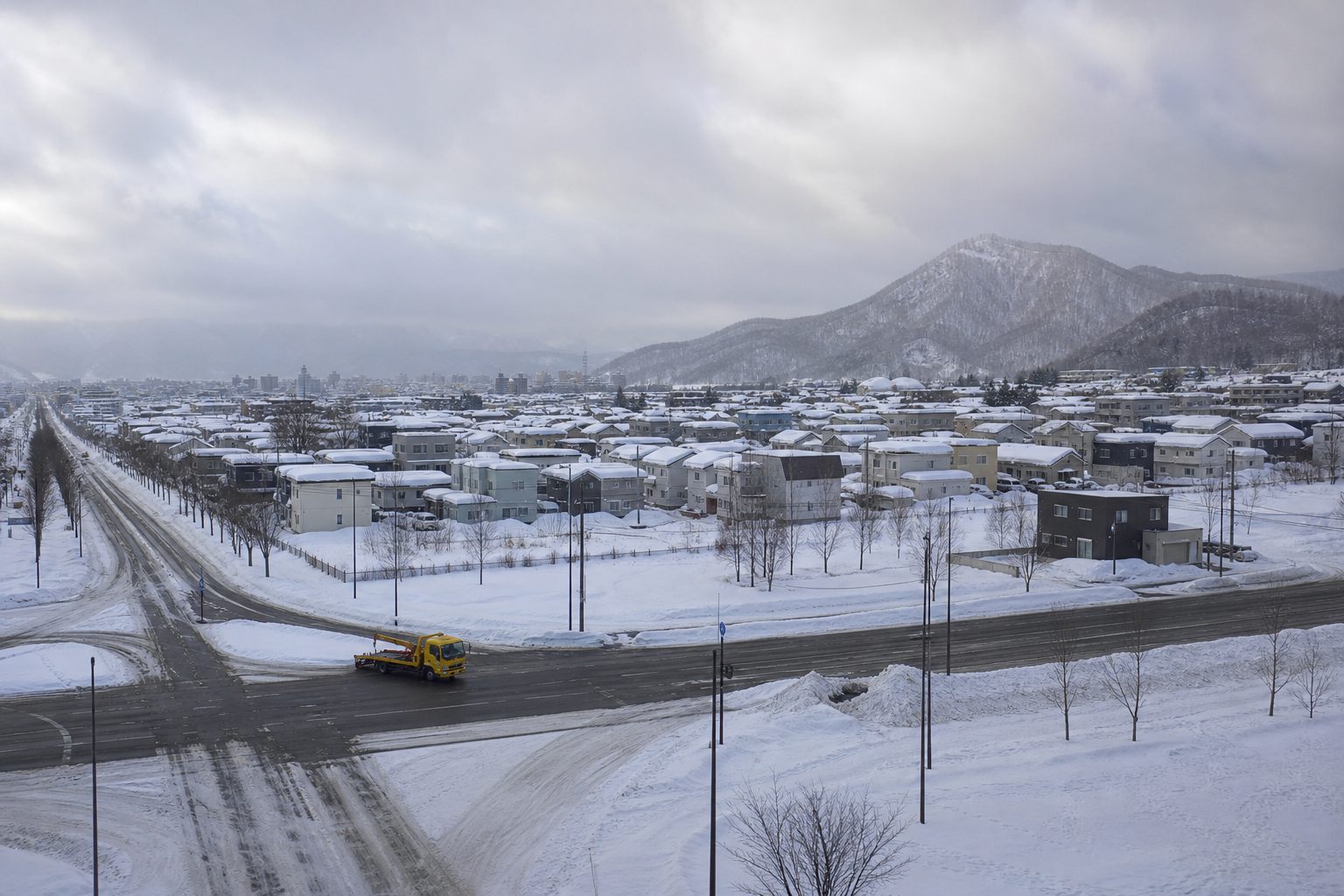 札幌近郊の冬の道路とレッカー車